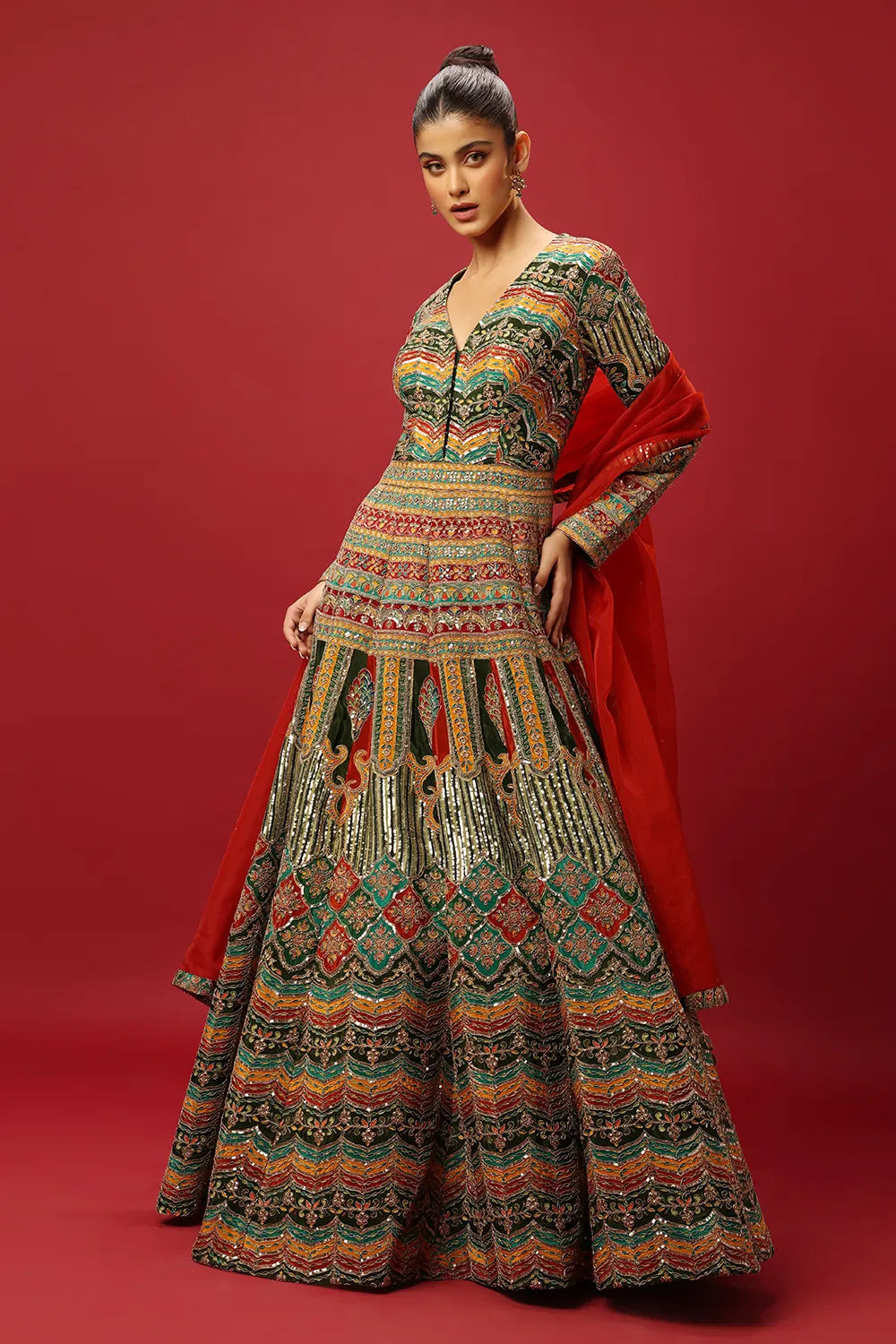 FERN GREEN AND RED CLASSIC MULTI COLOURED PRINTED ANARKALI GOWN SET WITH GOLD ZARI THREAD WORK PAIRED WITH A CONTRAST RED DUPATTA AND SEQUIN DETAILS.